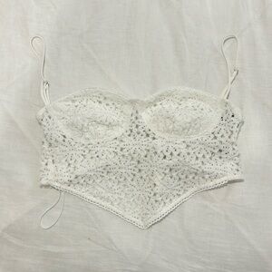 White lace going out top with a V hem and adjustable bow tie in the back.